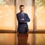 Marcos Moreno Rodríguez debout, bras croisés, dans la salle de réunion
