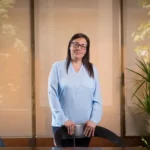 Núria Perez Iranzo debout, les mains posées sur la table de réunion