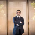 Ignaci Castilla Pérez debout, bras croisés, à côté d’une fenêtre dans une salle de réunion